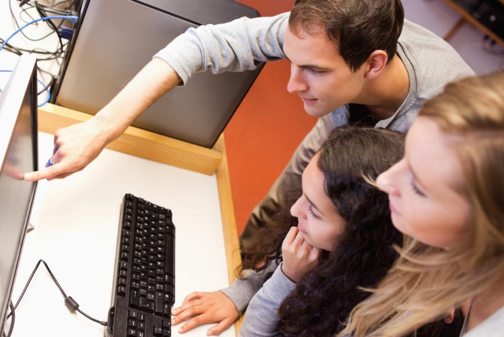 Compagni di studio che usano un computer in un'aula di informatica